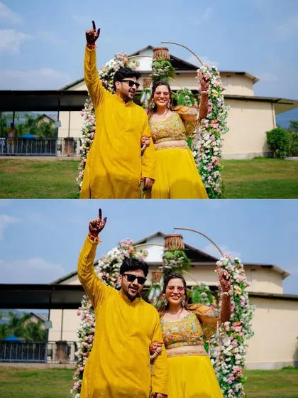 The happy couple posing under a beautiful floral arch after their Haldi ceremony. Their energy and excitement are infectious.