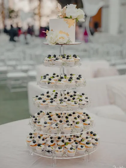 A full view of the magnificent cupcake tower, set up for an outdoor wedding. It's a beautiful and practical way to serve dessert to a large number of guests.