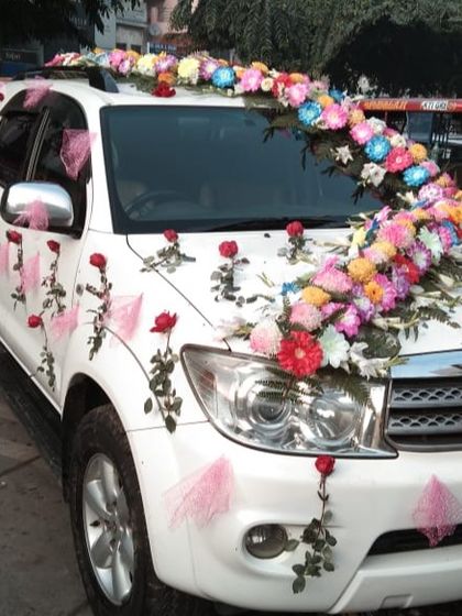 A colorful floral arrangement on a white Toyota Fortuner. I used a variety of multi-colored flowers to create a vibrant, flowing design perfect for a festive celebration.