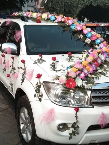 A colorful floral arrangement on a white Toyota Fortuner. I used a variety of multi-colored flowers to create a vibrant, flowing design perfect for a festive celebration.