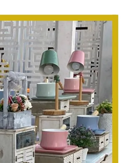 A wider view of the pastel decor station, showcasing a collection of rustic wooden boxes, floral baskets, and unique serving ware that creates a cohesive and whimsical theme.