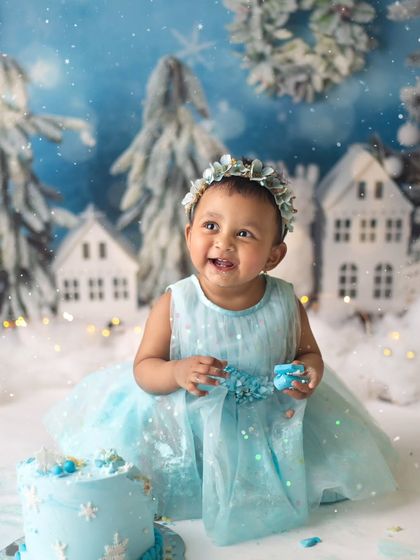 A happy smile from our winter princess. The soft blue dress and floral headband were the perfect touches for this magical, snowy first birthday theme.