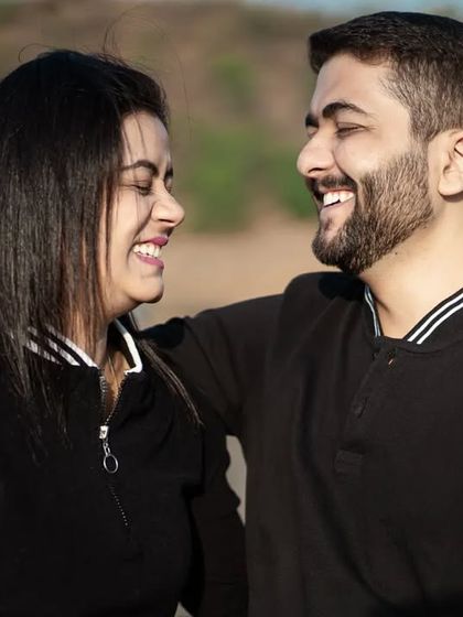 A close-up of the couple sharing a laugh. This tight crop emphasizes their expressions and the genuine connection between them, making for a heartwarming and authentic portrait.