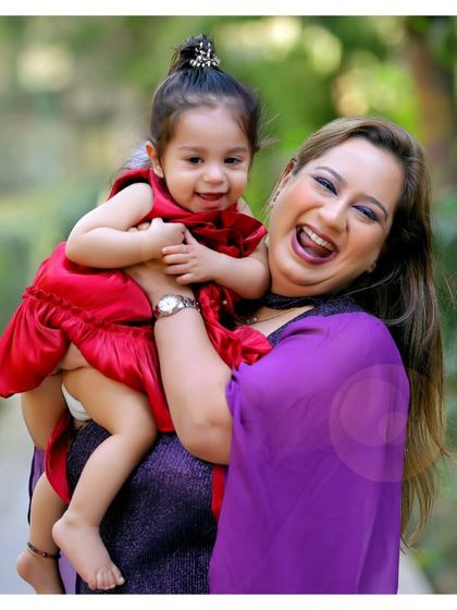 Pure happiness captured in a mother-daughter portrait. Her bright red dress and their shared laughter make this a vibrant and joyful image.
