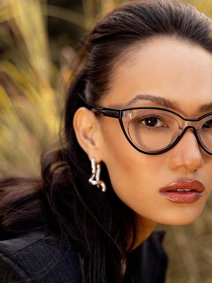 A direct, close-up shot of the John Jacobs cat-eye frames, showing the detail and fit of the eyewear.
