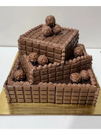 This 3-tier square cake is a chocolate lover's dream. It's fully covered in chocolate bars and topped with Ferrero Rocher, making it a rich and decadent choice for any large celebration.