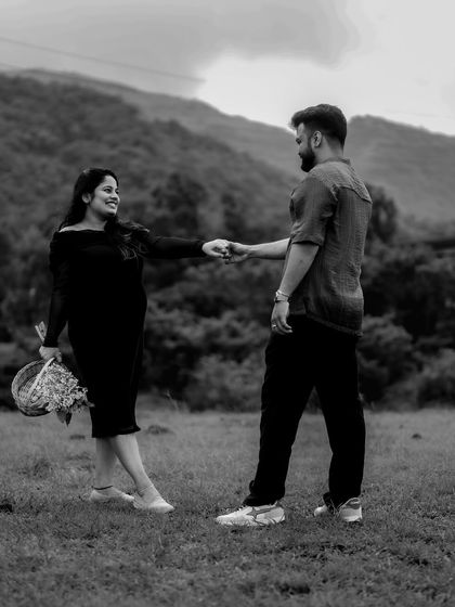 A black and white shot of the couple dancing in a field, surrounded by trees. The movement and their connection create a feeling of joy and freedom.
