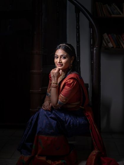 The moody lighting in this shot creates a dramatic and artistic portrait of the model in her Paithani saree.