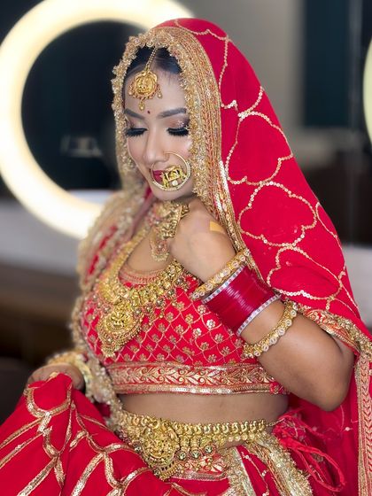 A candid moment of the bride adjusting her lehenga. Her makeup looks fresh and flawless even in a candid shot.