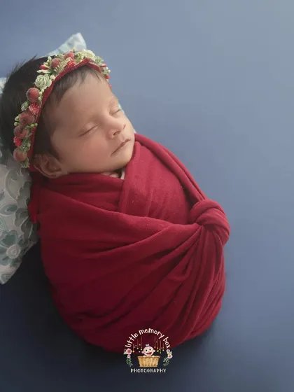 The rich red wrap against a deep blue background creates such a striking and beautiful contrast. I love using bold colors to create powerful and memorable newborn portraits.