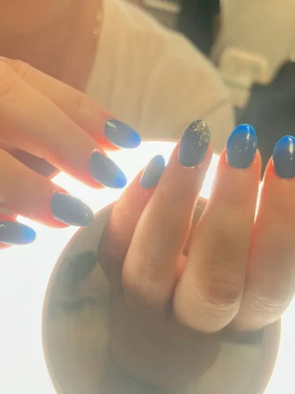 A beautiful blue manicure with a subtle glitter accent. A touch of sparkle can elevate any color.