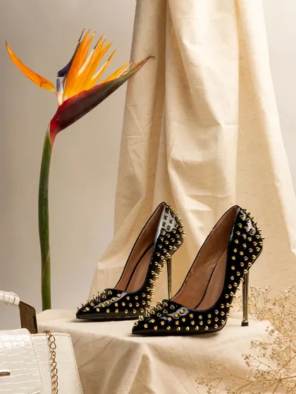 For this high-fashion footwear shoot, I used elegant props like a bird of paradise flower and soft drapery. The composition highlights the sharp design and studded texture of the black stiletto heels, creating a sense of sophisticated edge.