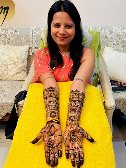 The same happy client from the previous video, posing with her full bridal mehndi. The design includes portraits, elephants, and traditional architecture, creating a rich and complete look.