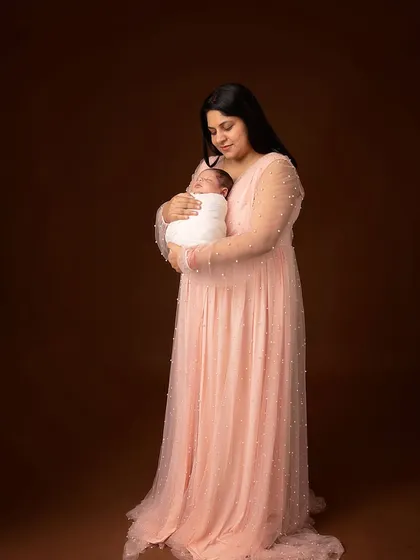 The same pose in color, with the mother in a beautiful pink gown. The warm brown background adds a sense of richness and depth to this classic portrait.