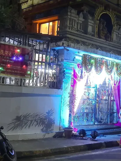 An event entrance set up right outside a temple, blending traditional elements with modern lighting for a community function.