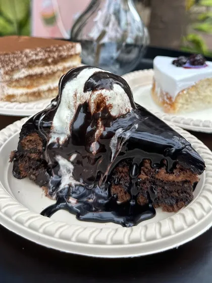 For the ultimate chocolate lover, we present our Chocolate Overload pastry. This decadent slice features a rich chocolate cake base, generously topped with chocolate sauce and a scoop of vanilla ice cream for a truly indulgent experience.