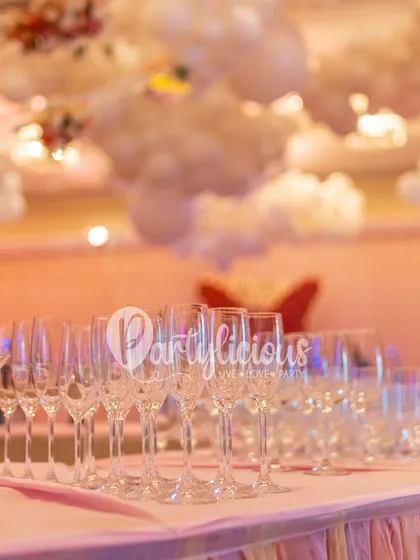 A sea of champagne glasses ready for a toast, set against a dreamy backdrop of balloon clouds, creating an atmosphere of pure celebration.