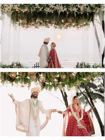 A perfect destination wedding moment in Goa, with the couple sharing their joy under a suspended floral mandap as the sun sets over the ocean.