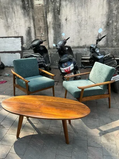 The teal lounge chairs paired with a mid-century style oval coffee table.