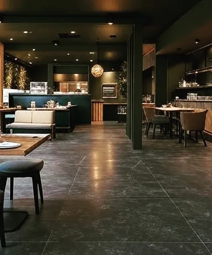 This restaurant interior uses a dark color palette, wood accents, and warm spotlights to create a cozy and intimate atmosphere. The layout includes a mix of booth seating and freestanding tables for flexibility.