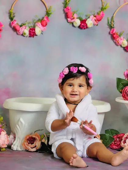 A full view of the floral spa day setup. The soft pastel background and abundance of flowers create a dreamy and feminine atmosphere for this sitter session.