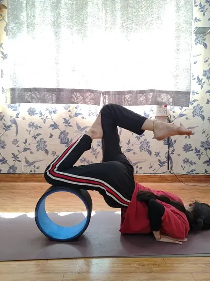 Using a yoga wheel can transform a practice. Here, a student performs an advanced backbend over the wheel, which helps to open the chest and shoulders while safely supporting the spine.