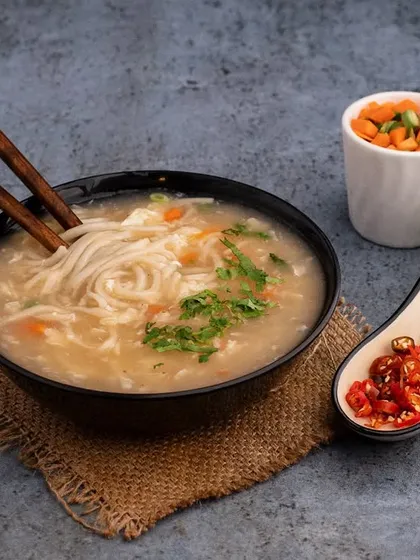 A comforting bowl of noodle soup styled and shot for My Sahibaan. The image is designed to look warm and inviting, perfect for a rainy day.