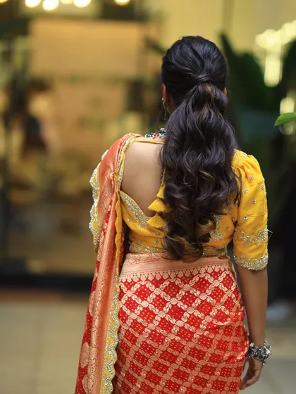 A back view of the textured ponytail. The waves add volume and interest to this classic hairstyle.