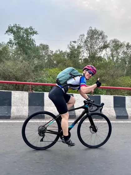 A female rider showing her strength and giving a thumbs-up.