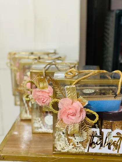 A lineup of my premium hampers, showcasing the elegant and festive packaging I use. These clear boxes are adorned with artificial flowers and gold accents, making the gift feel extra special.