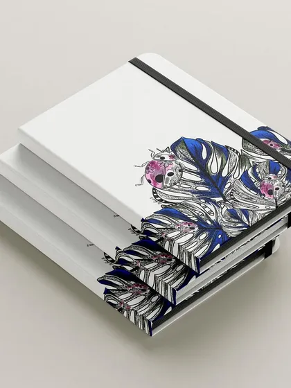 A stack of notebooks featuring my ladybug and monstera leaf design. I love creating art that people can use and carry with them every day.