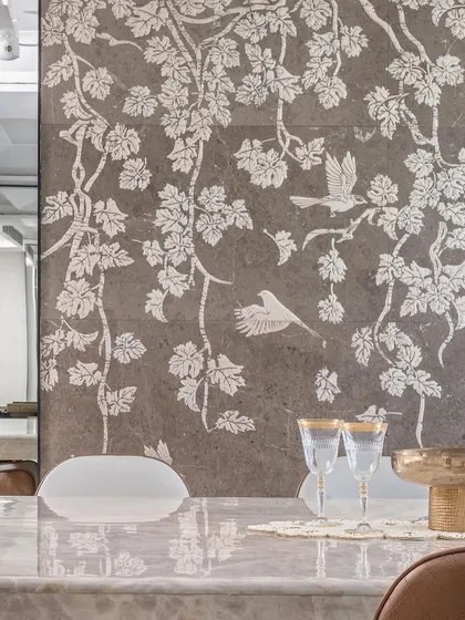 A detailed view of the exquisite stone mosaic inlay, featuring delicate birds and foliage. This custom art piece serves as a sophisticated focal point in the dining room, showcasing our commitment to bespoke craftsmanship.