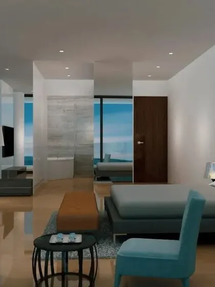 In this condominium design, the focus is on tranquility and the view. The bedroom is conceived as a serene, minimalist space with an open-concept bathroom, all oriented towards the expansive ocean vista.