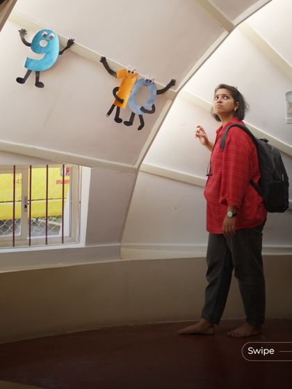 A student looks out the window of the kindergarten building. The windows are placed at a lower level to give children a connection to the outside world from their own perspective.