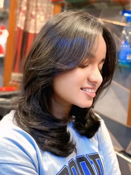 This is the result of a perfect layered haircut with feathered ends. The style adds incredible volume and movement, and the blowout styling makes the layers stand out beautifully.