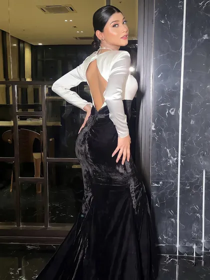 A view of the backless design of the gown. The sleek hairstyle and minimal accessories keep the look chic and sophisticated.