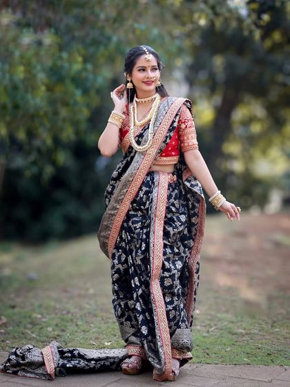 A full-length view of the black brocade Nauvari, showing its elegant drape and rich texture.
