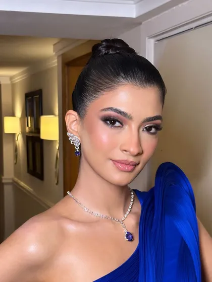 A modern, high-fashion makeup look. The clean bun, sculpted face, and defined eyes create a powerful and chic aesthetic, perfect for a Gaurav Gupta couture piece.