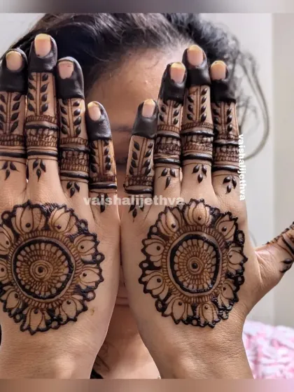 A bold and beautiful sunflower-style mandala. The dark, filled-in fingers create a striking contrast with the detailed palm design.