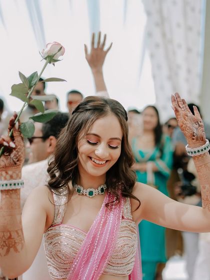 A happy bride dancing during her Mehendi ceremony. Her joyful expression and the festive atmosphere are what I aim to capture.