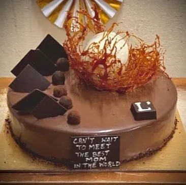 We bake for your most cherished moments. This custom Belgian Truffle Cake was designed for a baby shower, complete with a delicate spun sugar nest. We love adding a touch of artistry to your celebrations.
