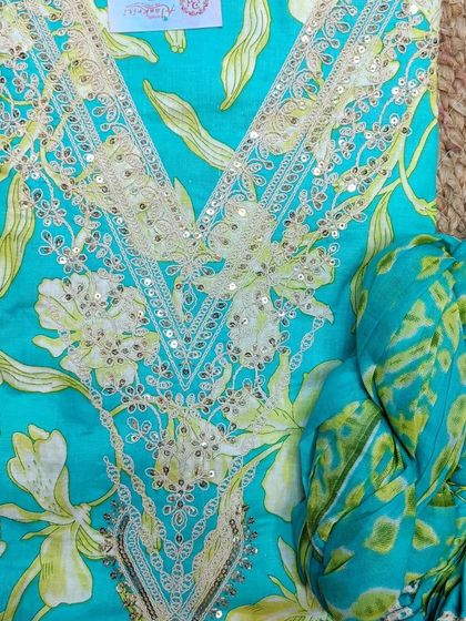 This turquoise floral suit piece is perfect for summer. The neckline is detailed with white sequin embroidery, adding a touch of sparkle.