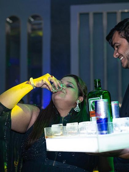 A guest enjoying a shot from a tray served by one of my smiling bartenders. The focus is on providing a fun, personal, and engaging service.