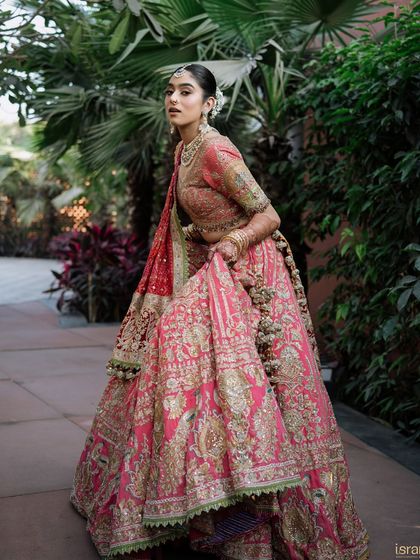 A powerful and elegant pose from the bride, showing off the beautiful drape and embroidery of her wedding outfit.
