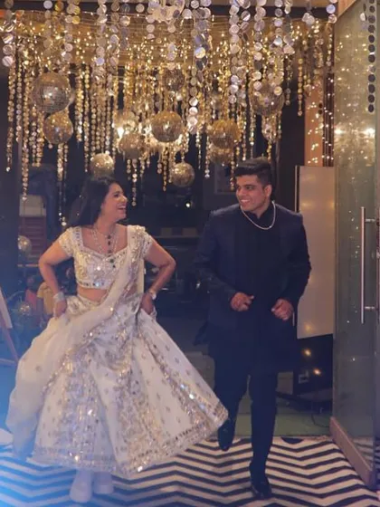 The grand entrance of the couple at their sangeet. The bride's radiant makeup ensures she is the center of attention.