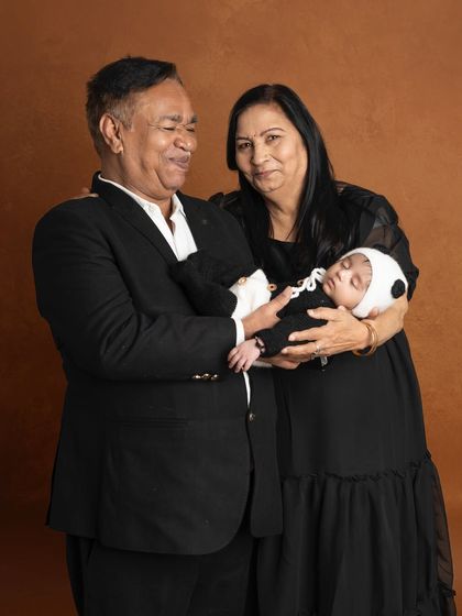 The special bond between grandparents and their grandchild. The pride and love in their expressions as they hold the sleeping newborn is a truly priceless moment.