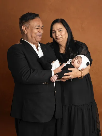The pride and joy in a grandparent's eyes as they hold their new grandchild. This portrait captures a tender moment between three generations.