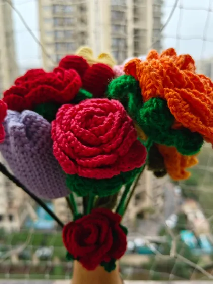 My handmade crochet bouquet set against a balcony view, showing how these vibrant, everlasting flowers can bring color and life to any setting, indoors or out.