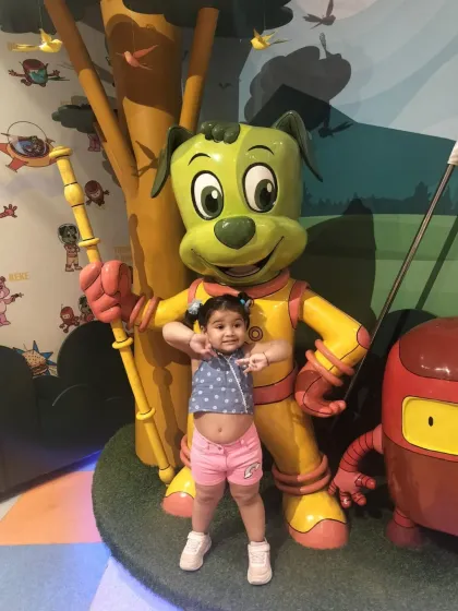A little girl strikes a fun pose with Tinga Dojo, showing off her happy energy.