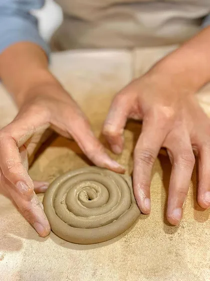 Creating a perfect spiral with a coil of clay is the first step to building a beautiful and sturdy coiled pot or bowl.